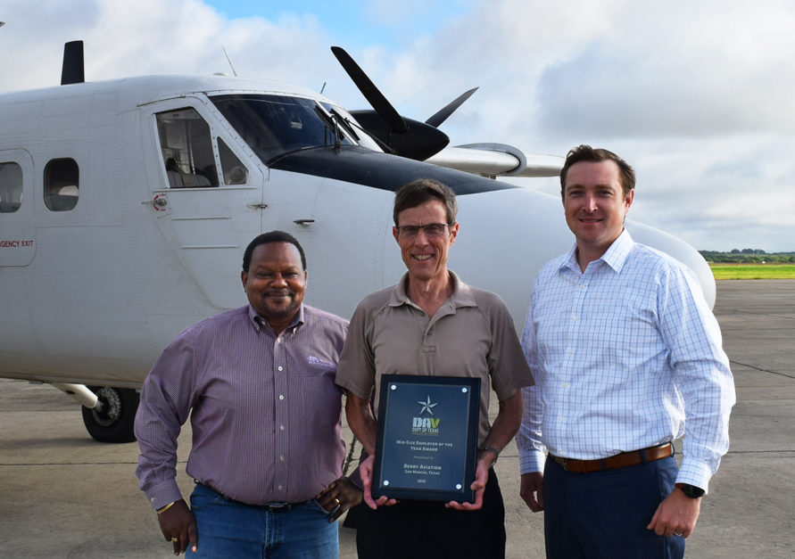 Berry Aviation President Stan Finch holds the DAV Department of Texas Midsize Employer of the Year Award alongside Warren Orr Senior Director of HR) and Austin Vermillion Vice President of Government Services).